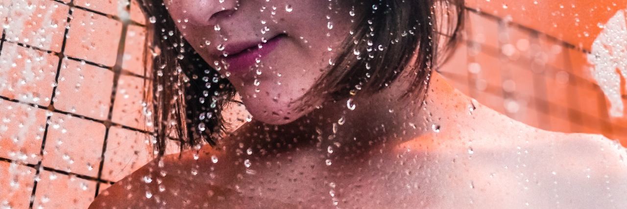 Tips for Showering With Depression woman showering looking down with eyes closed