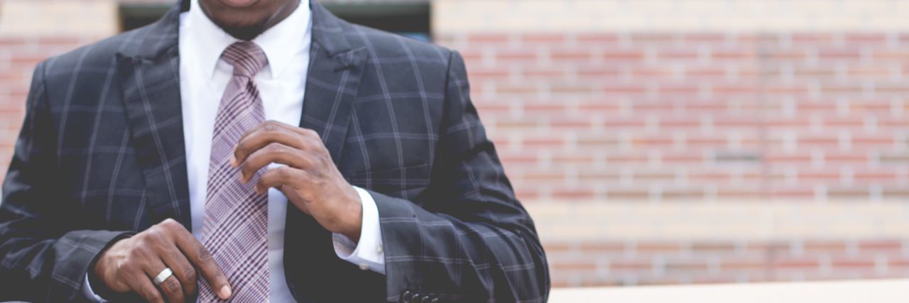 Disabled, LGBTQIA+, People of Color or Religious Minority Therapists man person of color wearing suit and tie and sitting on bench