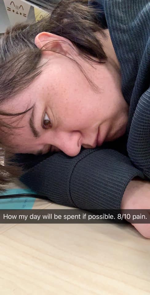 woman putting her head on her desk with the caption 'how my day will be spent if possible. 8/10 pain.'