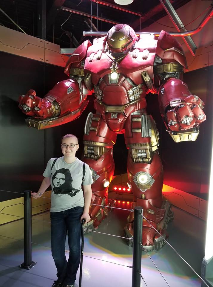 a person standing in front of a large iron man display