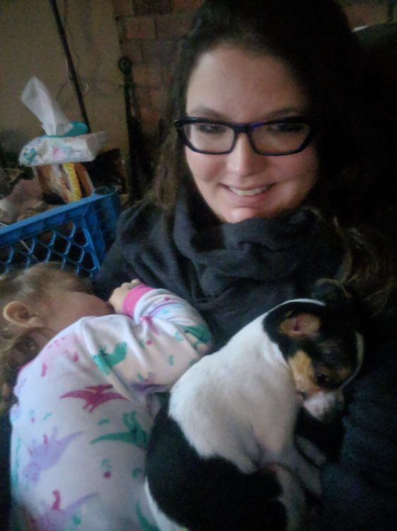 woman holding baby and puppy in her arms