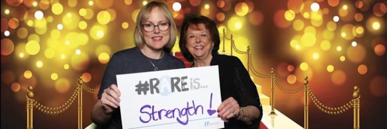 FDA Approves Drug for Lambert-Eaton Myesthenic Syndrome Betty and her friend holding a sign saying "rare is strength"