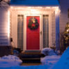 House front door decorated with Christmas wreath, lights and a snowman.