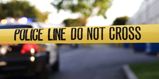 Learning to Thrive as a Violent Crime Survivor With a Disability Home invasion robbery, woman in a wheelchair attacked. A blurred police car in the background behind yellow crime scene tape.