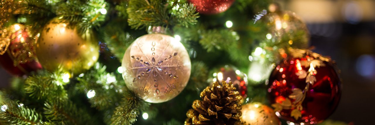 How to Reduce Stress During the Holidays With Chronic Illness close up of ornaments hanging on a christmas tree