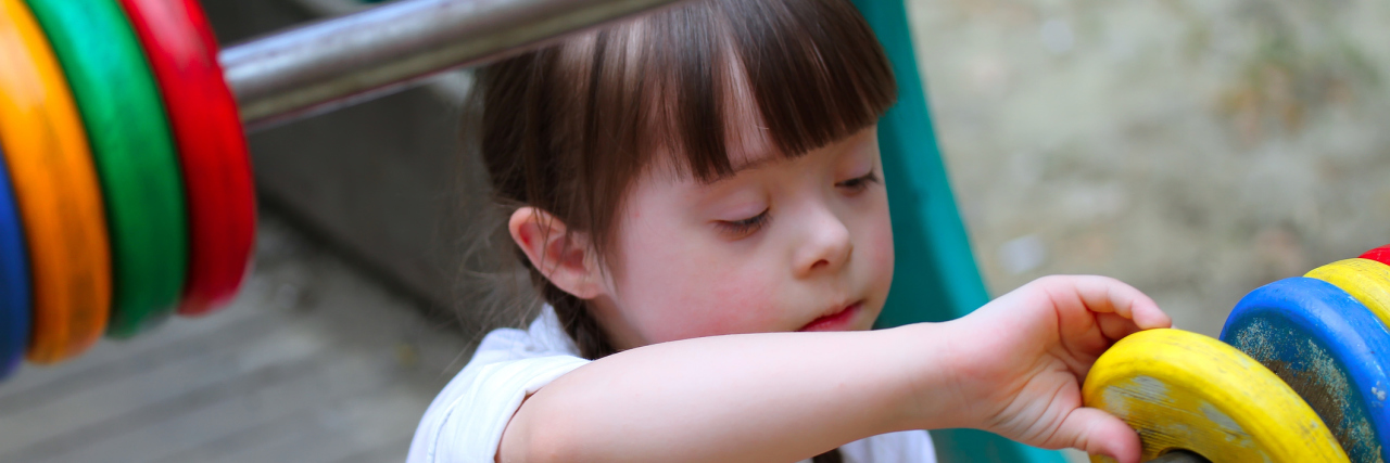 Girl With Down Syndrome Wandered Away From School Little girl with Down syndrome playing alone in a playground.