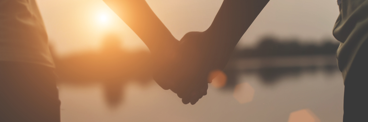 Learning to Accept Help When Parenting a Child With a Disability Closeup of two hands holding