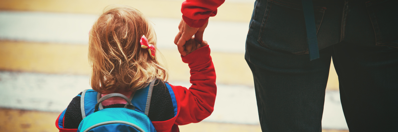 Mother walking daughter to school.