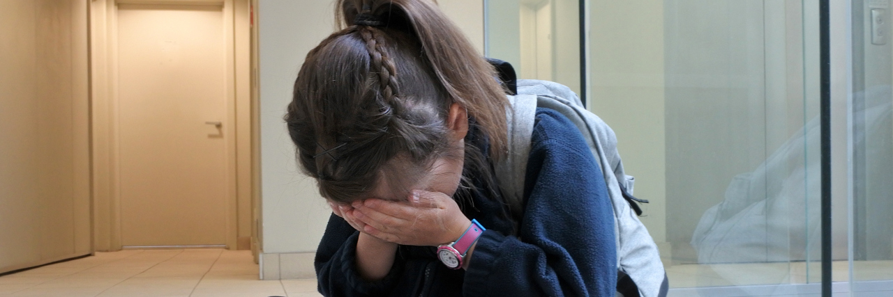 Girl crying at school because of bullying.