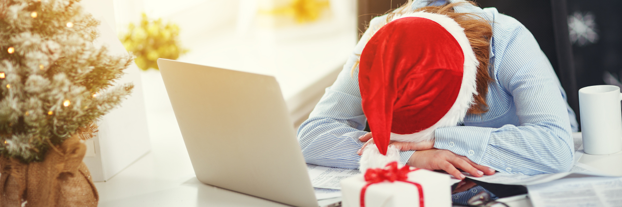 7 Tips For Surviving the Holidays With a Brain Injury woman tired, asleep working at computer at Christmas