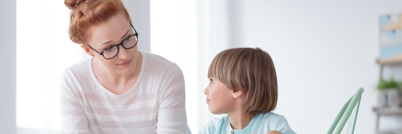 How to Help a Child Who Is Afraid of Pediatric Counseling Young female school psychologist having conversation with little boy at office
