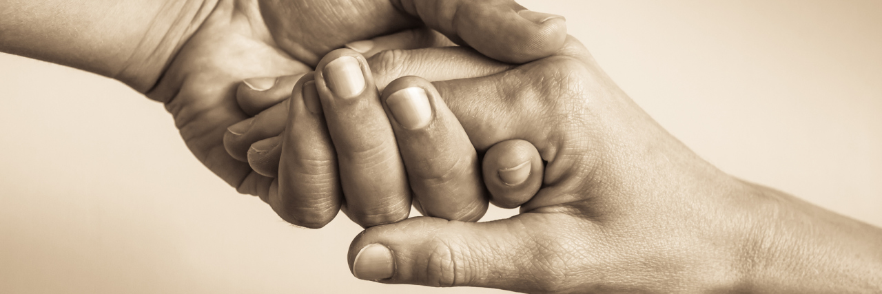 The Compassion and Nobility of Friends Who Help Those With Illness sepia photo of offering a helping hand