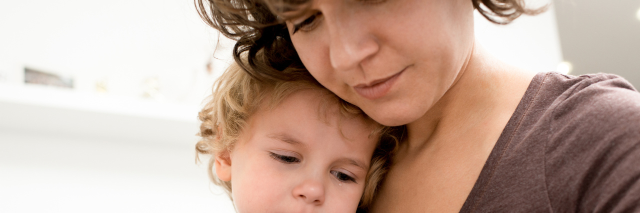 Mental Illness Adds Another Layer to My 'Mom Guilt' Close up portrait of cute little boy crying on mothers lap after being hurt