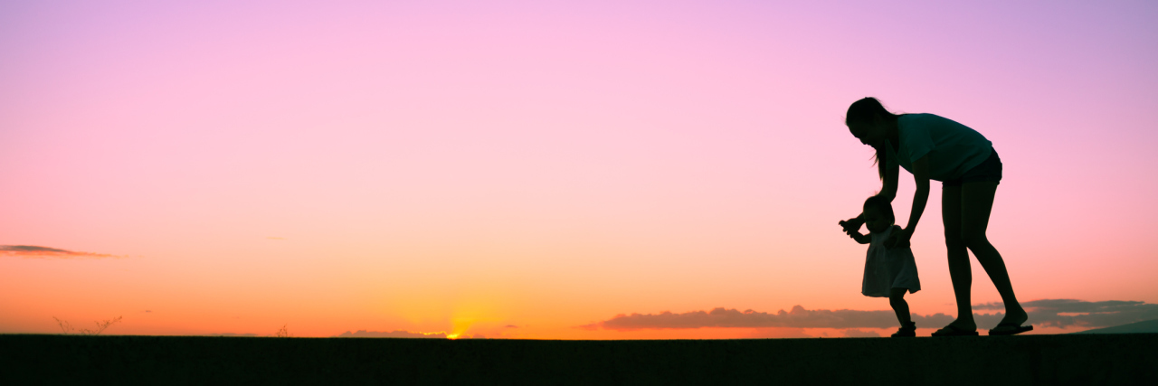Deciding Not to Have Another Child After Pregnancy Loss silhouette of mother and young daughter walking outside at sunset