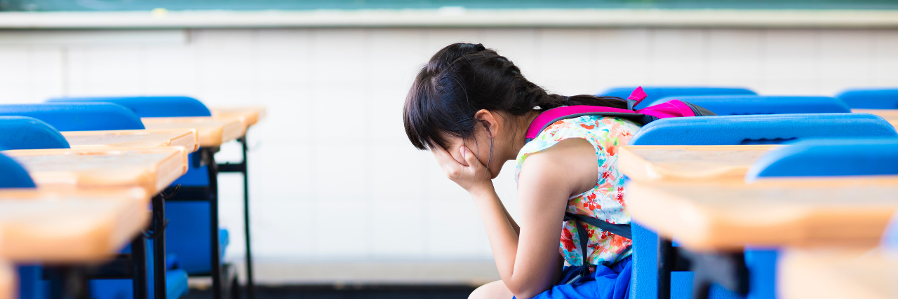 New Bill Aims to Reduce Restraint, Seclusion in Schools Girl alone in classroom covering her face with her hands