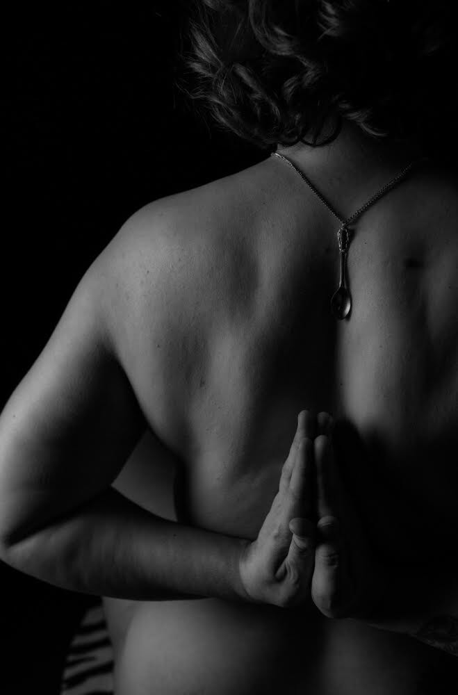 Jenny nude, shown from the back with her hands held together as if in prayer.