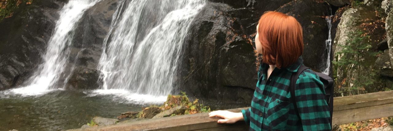 Making Meaning Out of Life With Chronic Illness the author standing with her walker by a waterfall