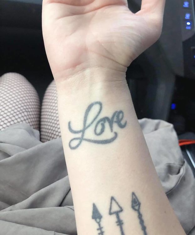 tattoo that says "love" on wrist