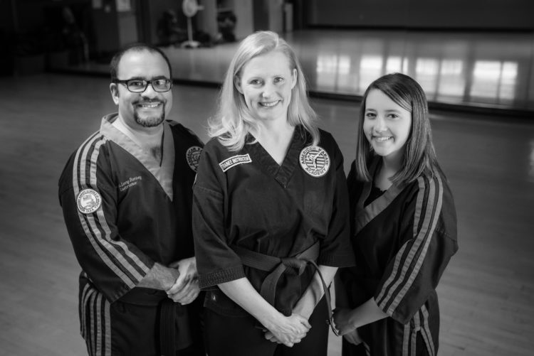 man, woman and daughter wearing martial arts outfits