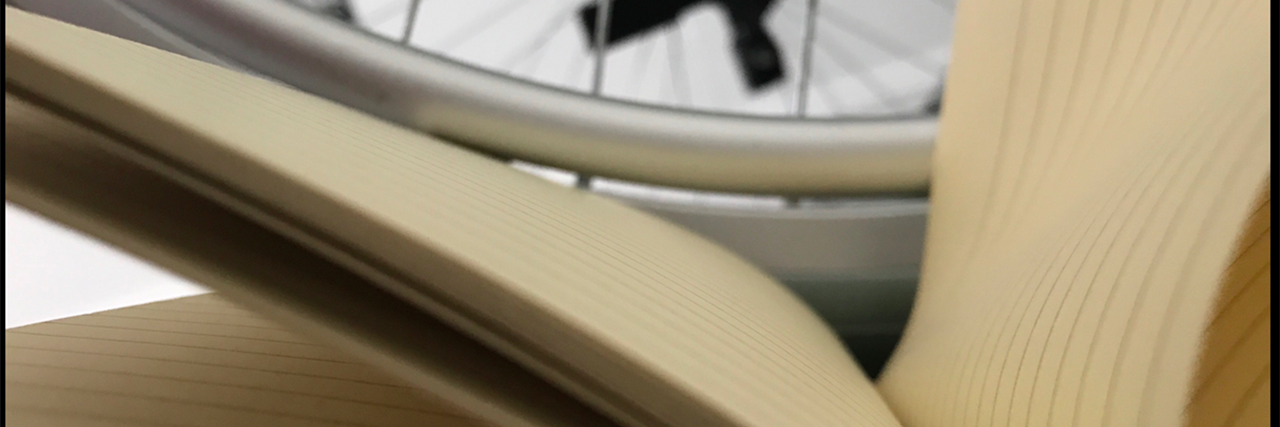 9 Tips for Writing About Characters With Disabilities Wheel of wheelchair and book.