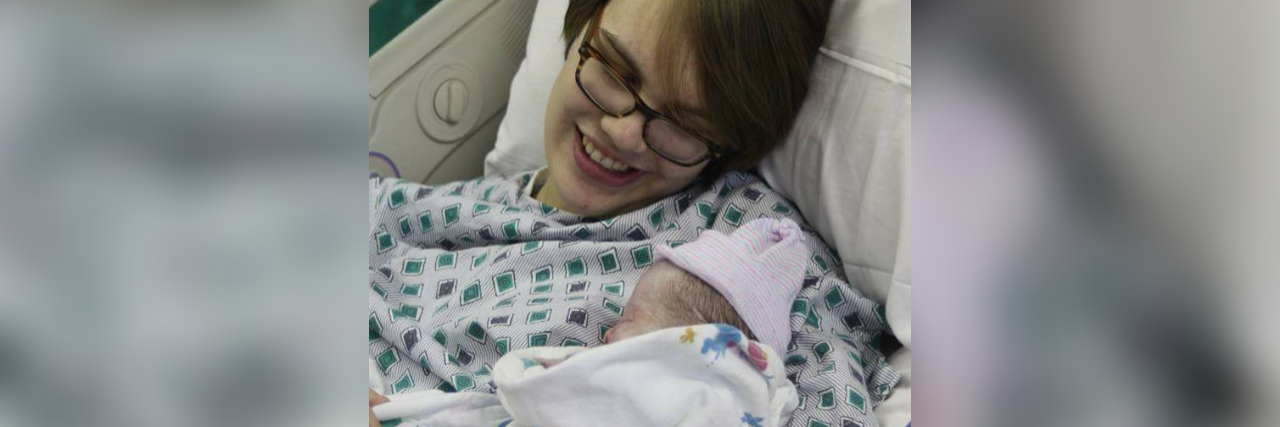 the author lying in a hospital bed holding her newborn baby