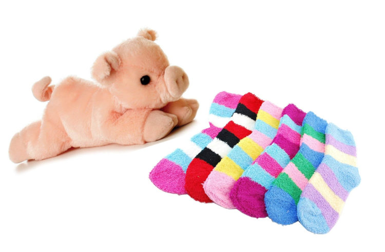 Pink stuffed animal pig and striped, colorful fuzzy socks