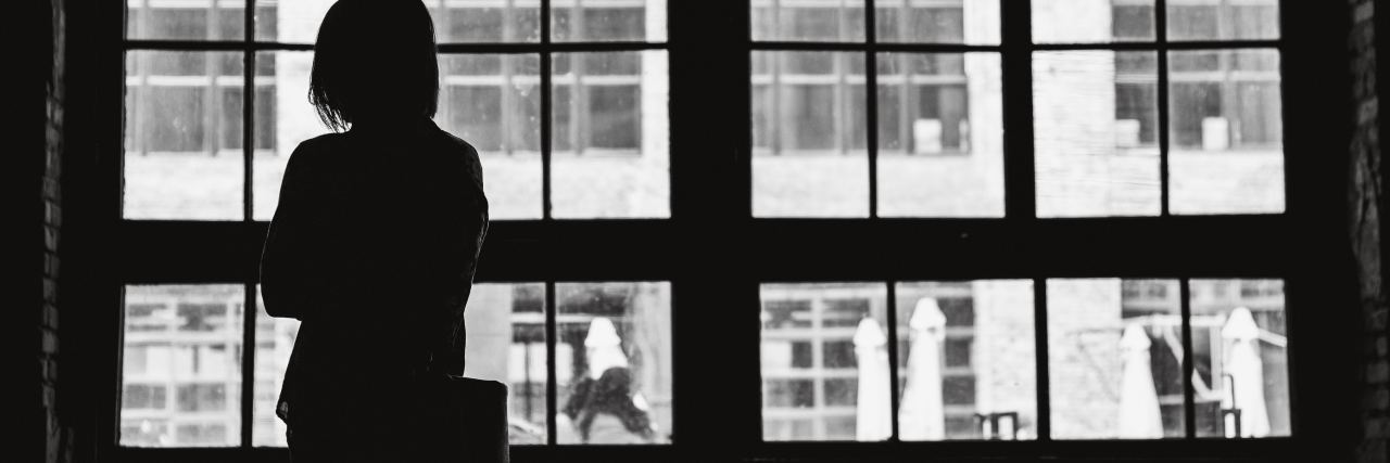 woman silhouetted in front of window in black and white