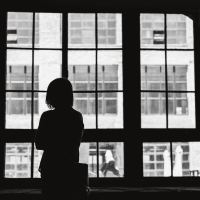 woman silhouetted in front of window in black and white