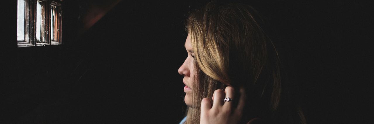 Borderline Personality Disorder Is Not Like the Stigma blonde woman in partial darkness illuminated by window she is looking out of