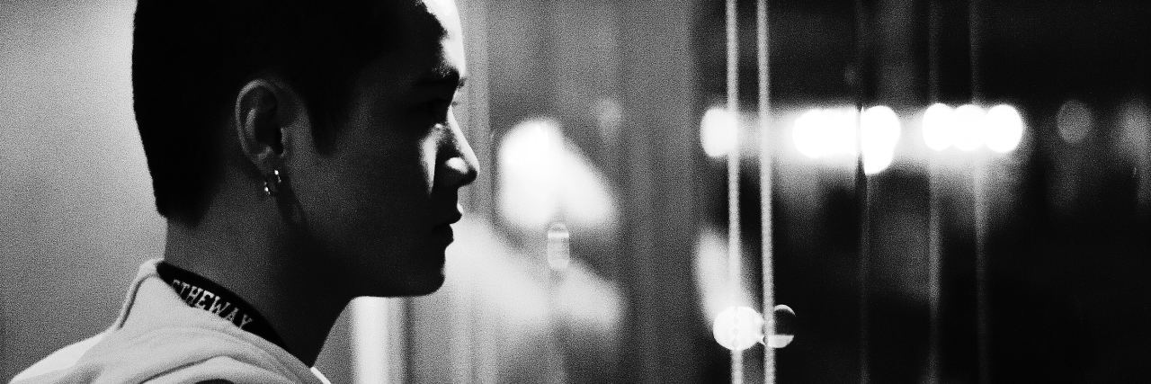 black and white photo of man in profile in front of mirror