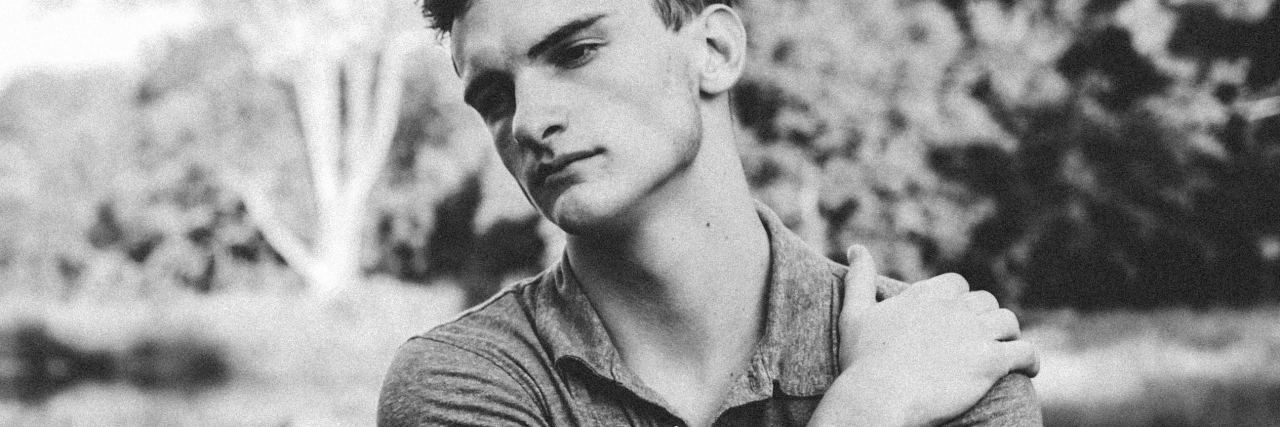 I Can't Really Be a Person Today black and white photo of man looking into distance with his hand on his shoulder