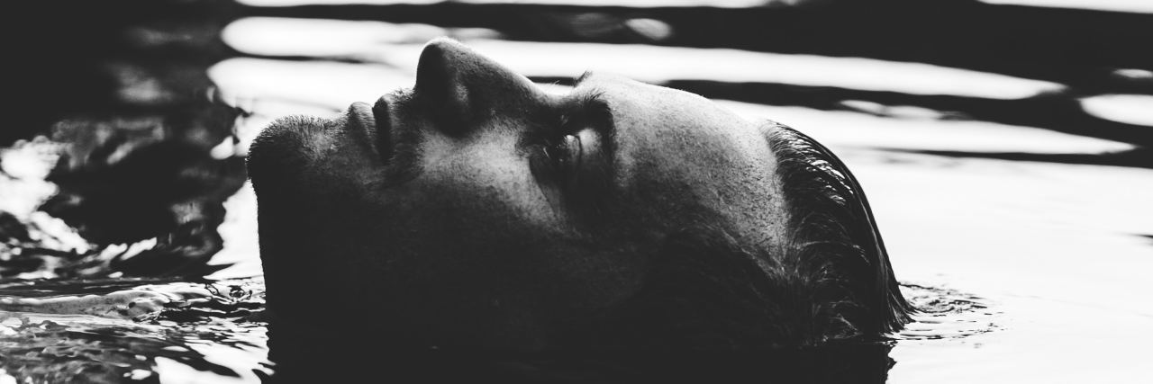 When You Look Shy but Are Actually Depressed black and white photo of man's face in water with rest of him submerged