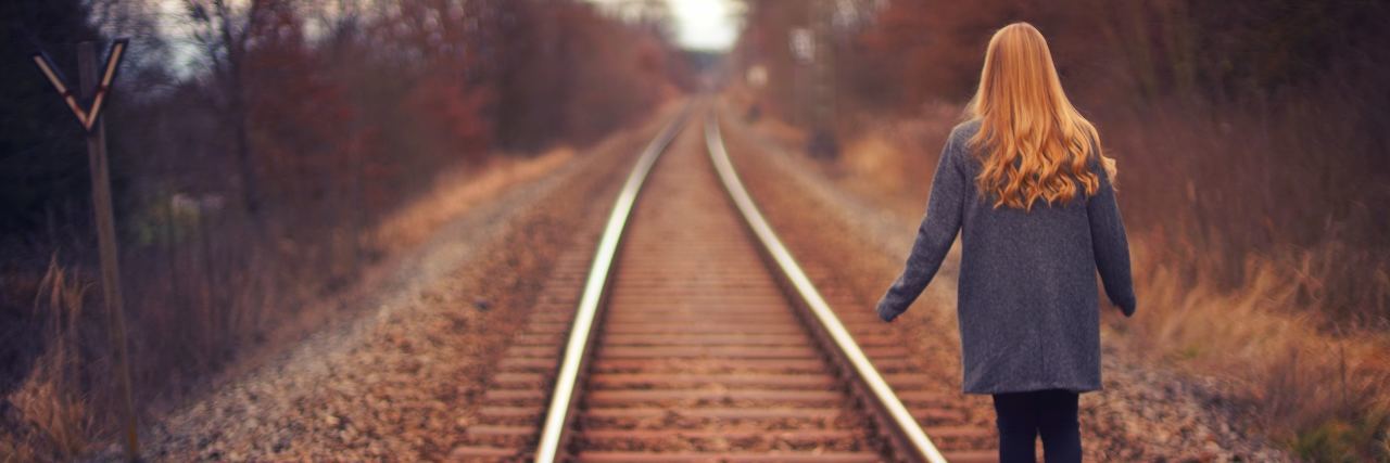How Borderline Personality Disorder 'Splitting' Affects Someone woman walking down train tracks
