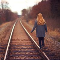 woman walking down train tracks