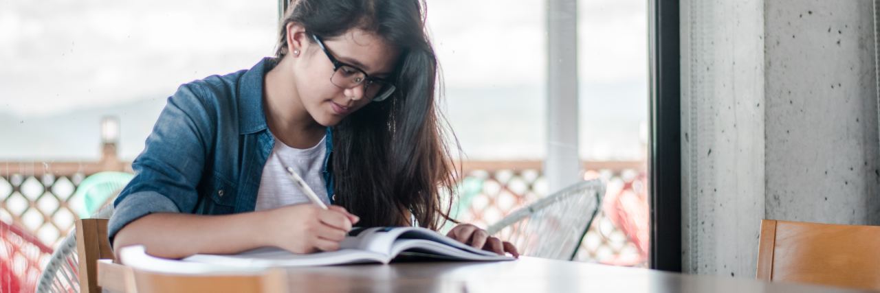 Warning Signs Depression Is Getting Worse young woman with dark hair and glasses studying on table