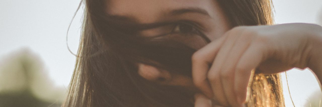 When You Need a Job, But Have Low Self-Esteem young woman partially covering face with hair while looking into camera