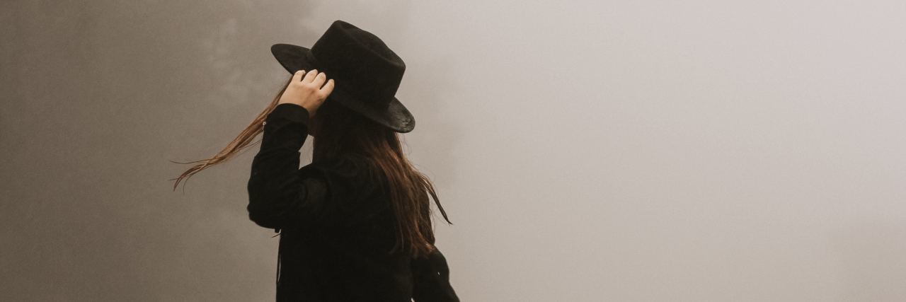 Why Do You Fear Abandonment Because of BPD? photo of woman standing in road in thick fog wearing hat and dress