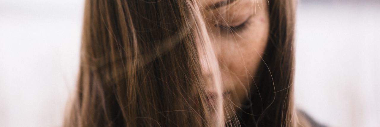 When You Feel Insecure and Like You Don't Deserve Love young woman with long brown facing down with eyes closed