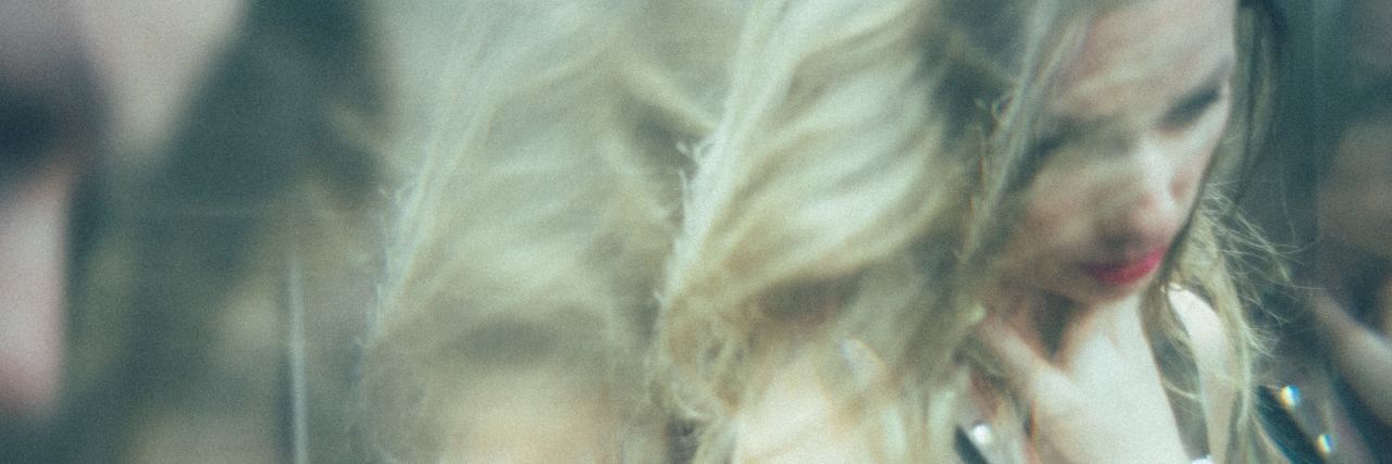 Ways Hypomania Can Be Destructive woman reflected in mirror doubled and blurred