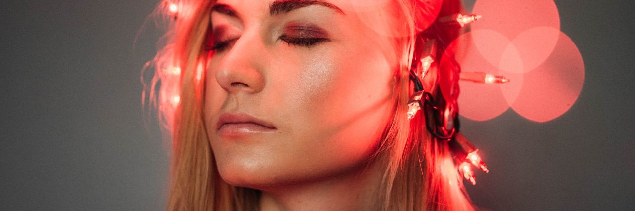 I Prefer the Term 'Personalities' for Dissociative Identity Disorder photograph of blonde woman with red fairy lights around her head and blurred red bokeh effect with lights out of focus