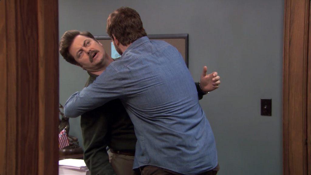 ron swanson looking uncomfortable during a hug