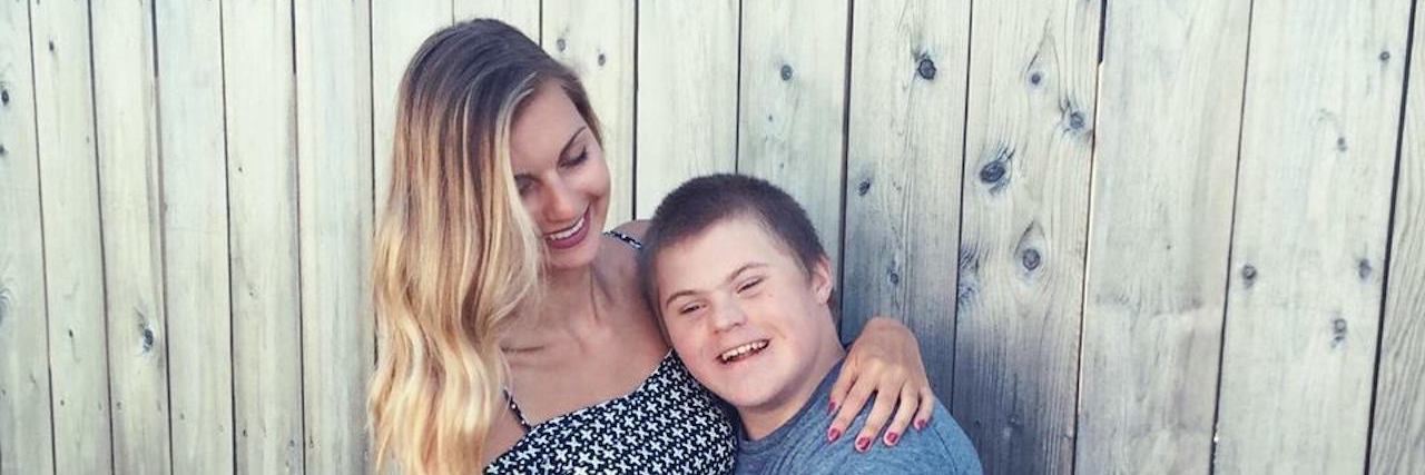 Letter to Siblings of Kids With Down Syndrome Brother and sister hugging each other. Sister is looking down at her brother while he smiles, resting his head on her shoulder.