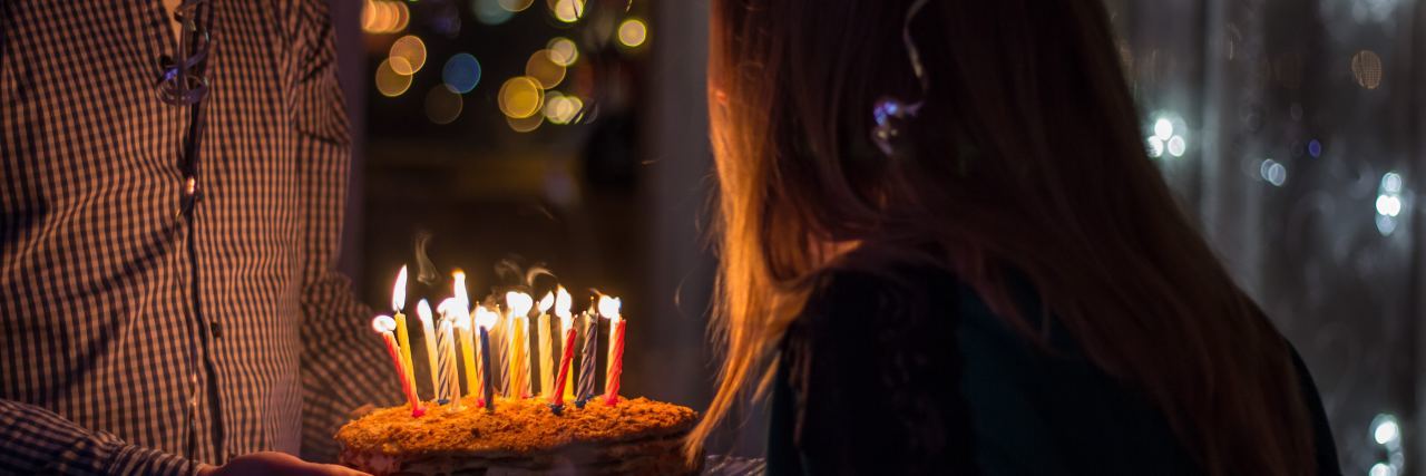 Why Lupus Makes Me Grateful for My Birthday woman blowing out candles on her birthday cake