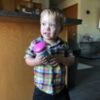 Little boy with Down syndrome holding a sippy cup.