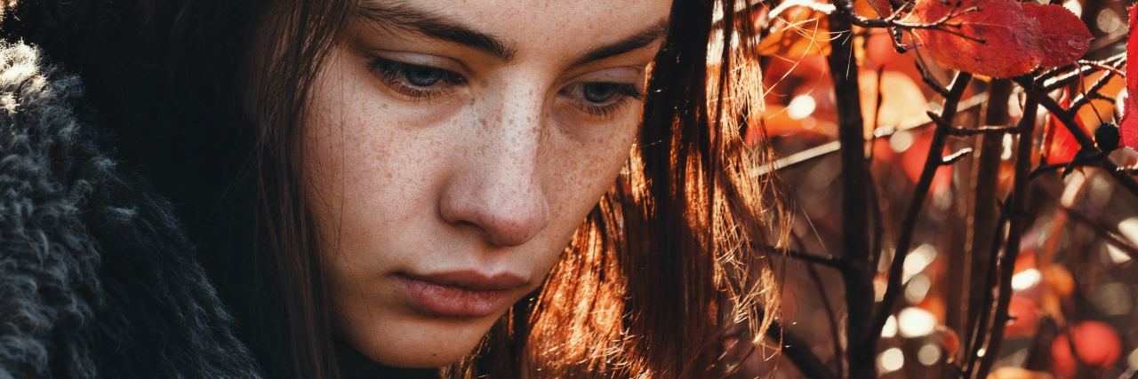 For Teenagers With Depression: Does It Really Get Better? teenage girl looking sad in front of autumn red fall leaves