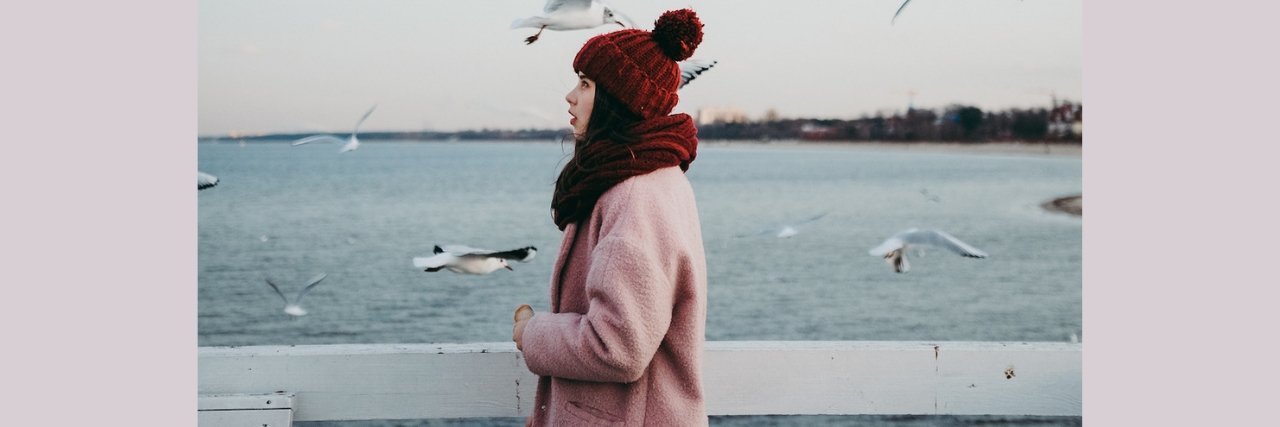 What to Do When You're Lonely During the Holidays A woman in a winter coat and hat standing by the water. Text reads: 10 Things to Do When You Feel Like You Don't Have Anybody for the Holidays
