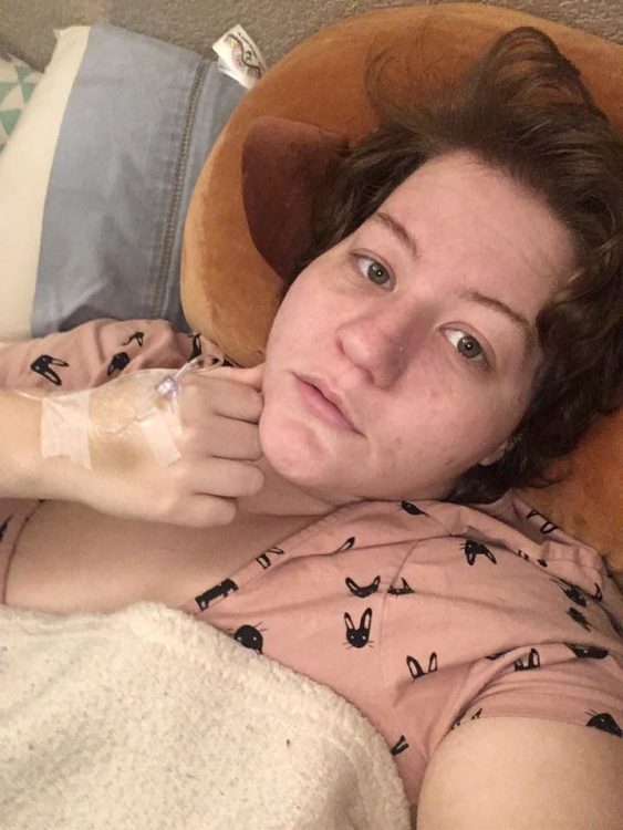 woman lying in bed with iv in hand