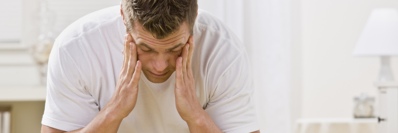 Tips for Managing Sleep Deprivation man sitting on his bed looking tired