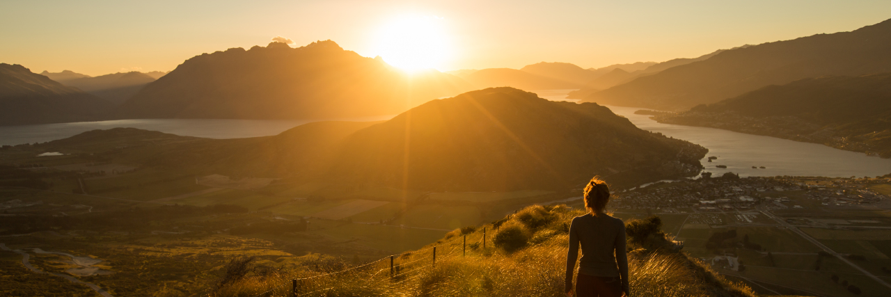 Making Treatment Decisions as a Disabled Young Adult Woman silhouetted at sunset on a mountain.