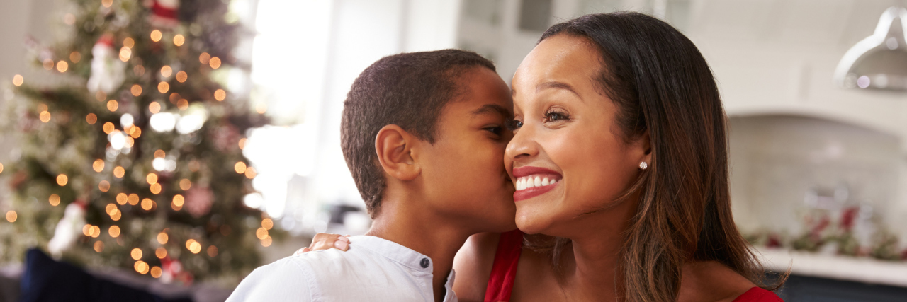 Gifts for Parents of Kids on the Autism Spectrum Son kissing mom with Christmas present